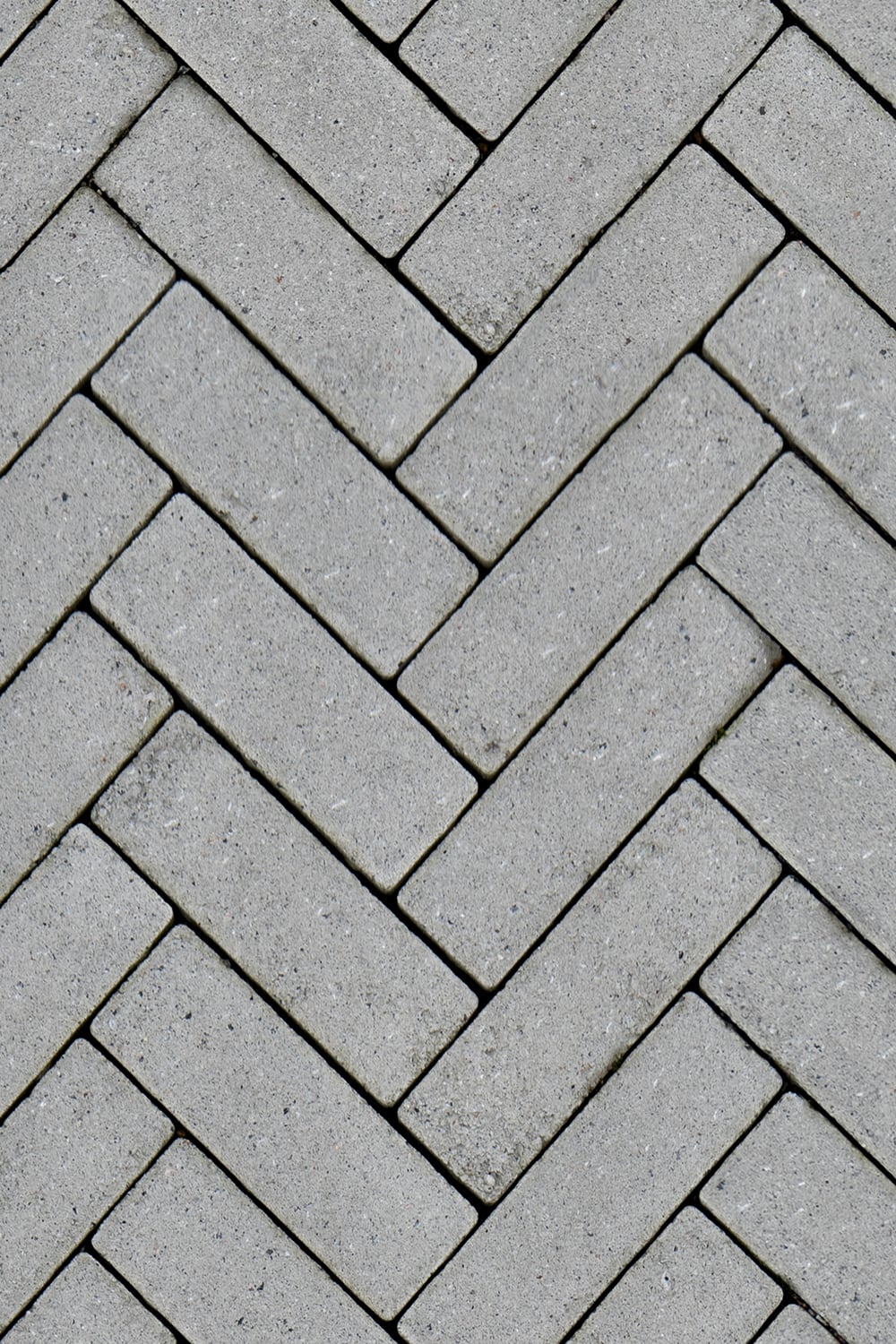 Concrete brick tiled floor with zigzag pattern close up seamless texture