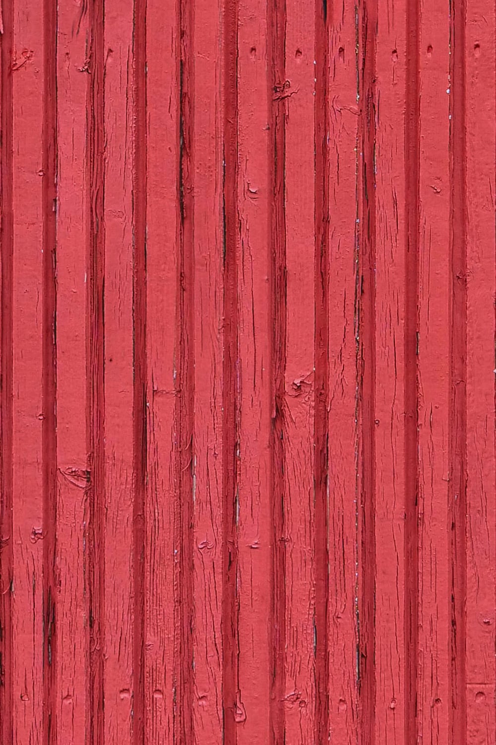 exterior wood paneling with red flaking paint - close up