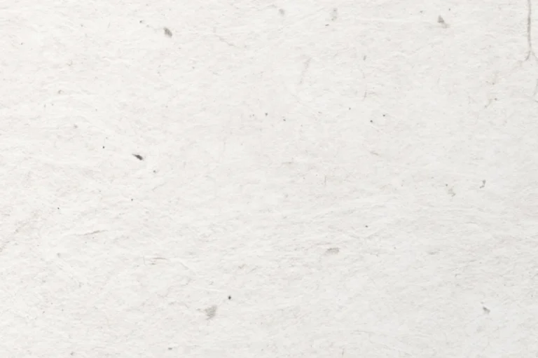 Close-up of a handmade paper with a few small dark colored specs