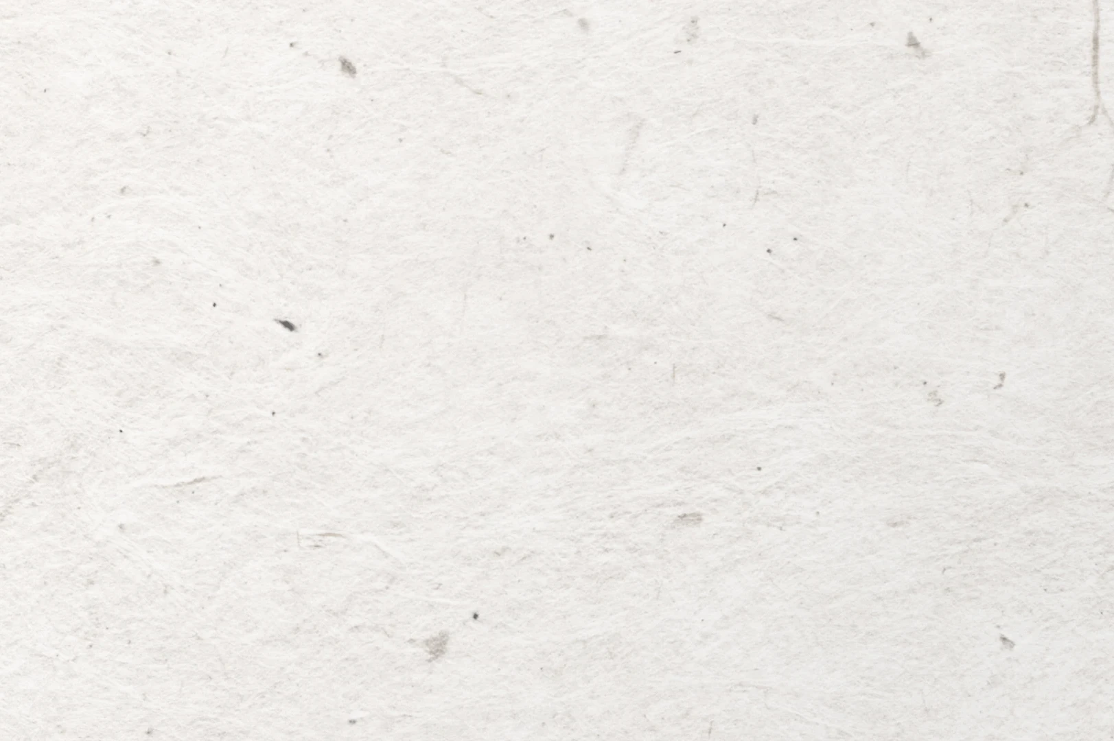 Close-up of a handmade paper with a few small dark colored specs