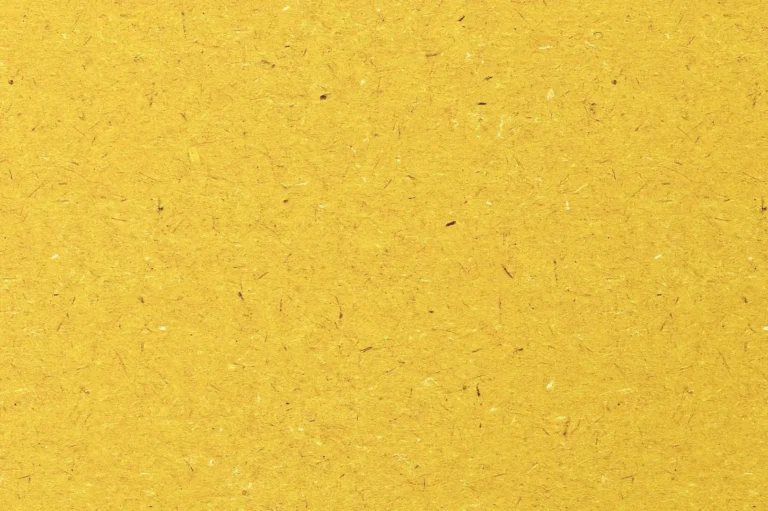Close-up of an orange recycled paper with lots of different shades of fibers