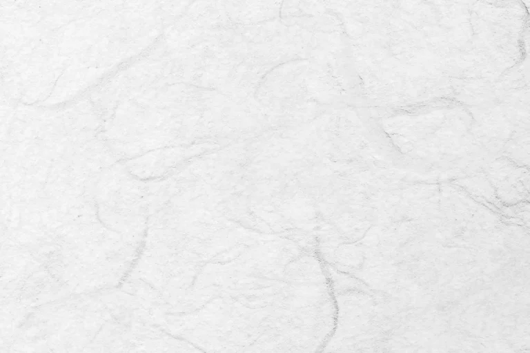 Close-up of a handmade white paper with random darker fibers
