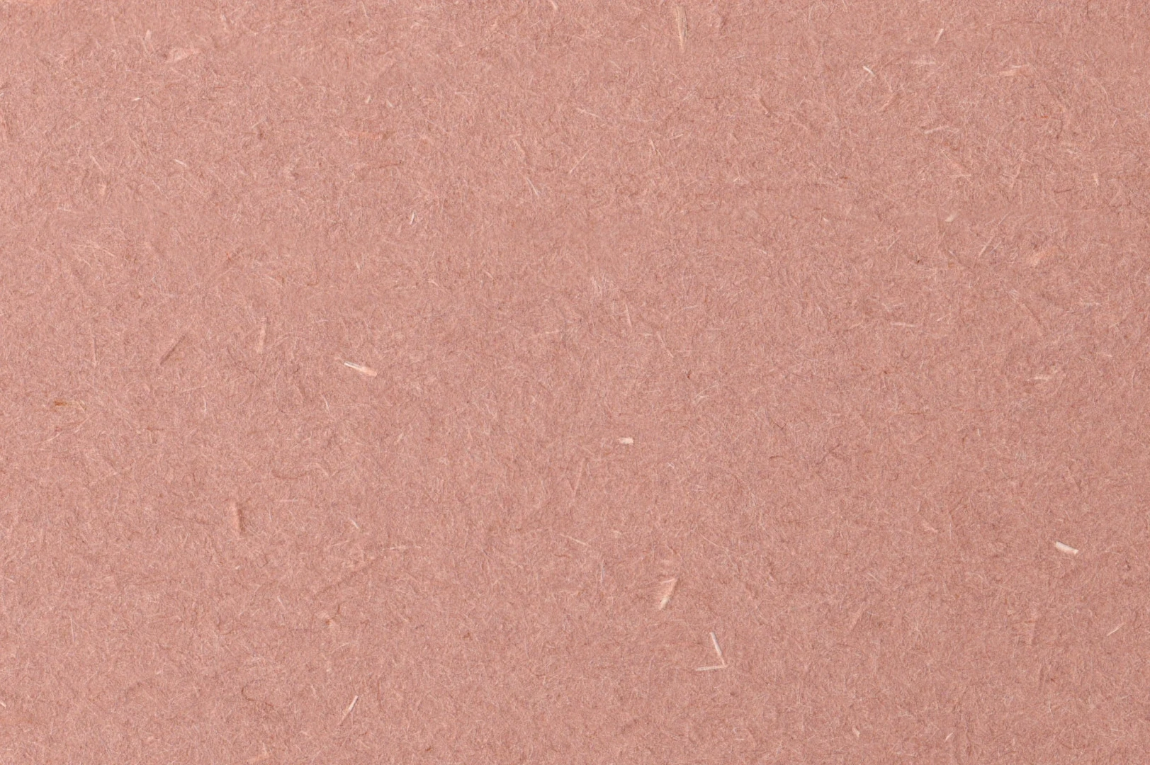 Close-up of recycled paper with speckles of white fibers