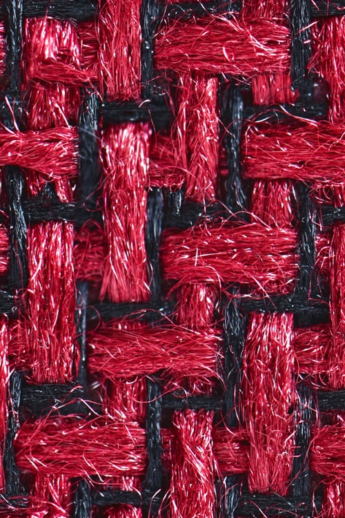 Close-up of a plastic textile with red and black fibers woven in zigzag