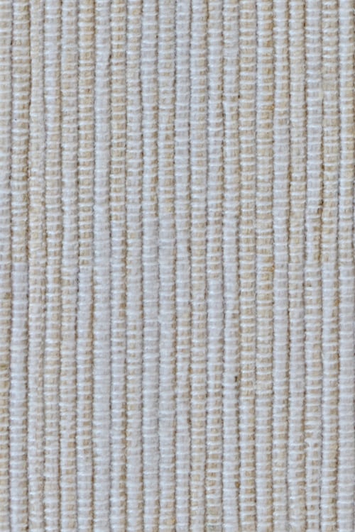 Close-up of a simple handwoven rug with white and beige color tones