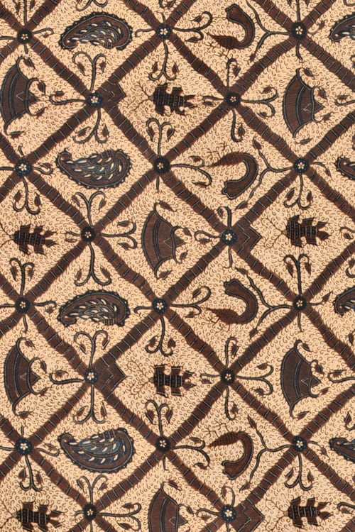 Close-up of a hand painted batik with diamond shapes and floral motifs