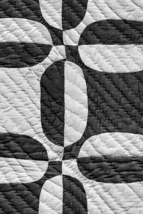 Close-up of a quilted duvet with geometric black and white pattern