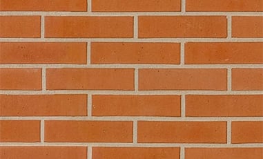 Clean red brick wall with fine white grouting.