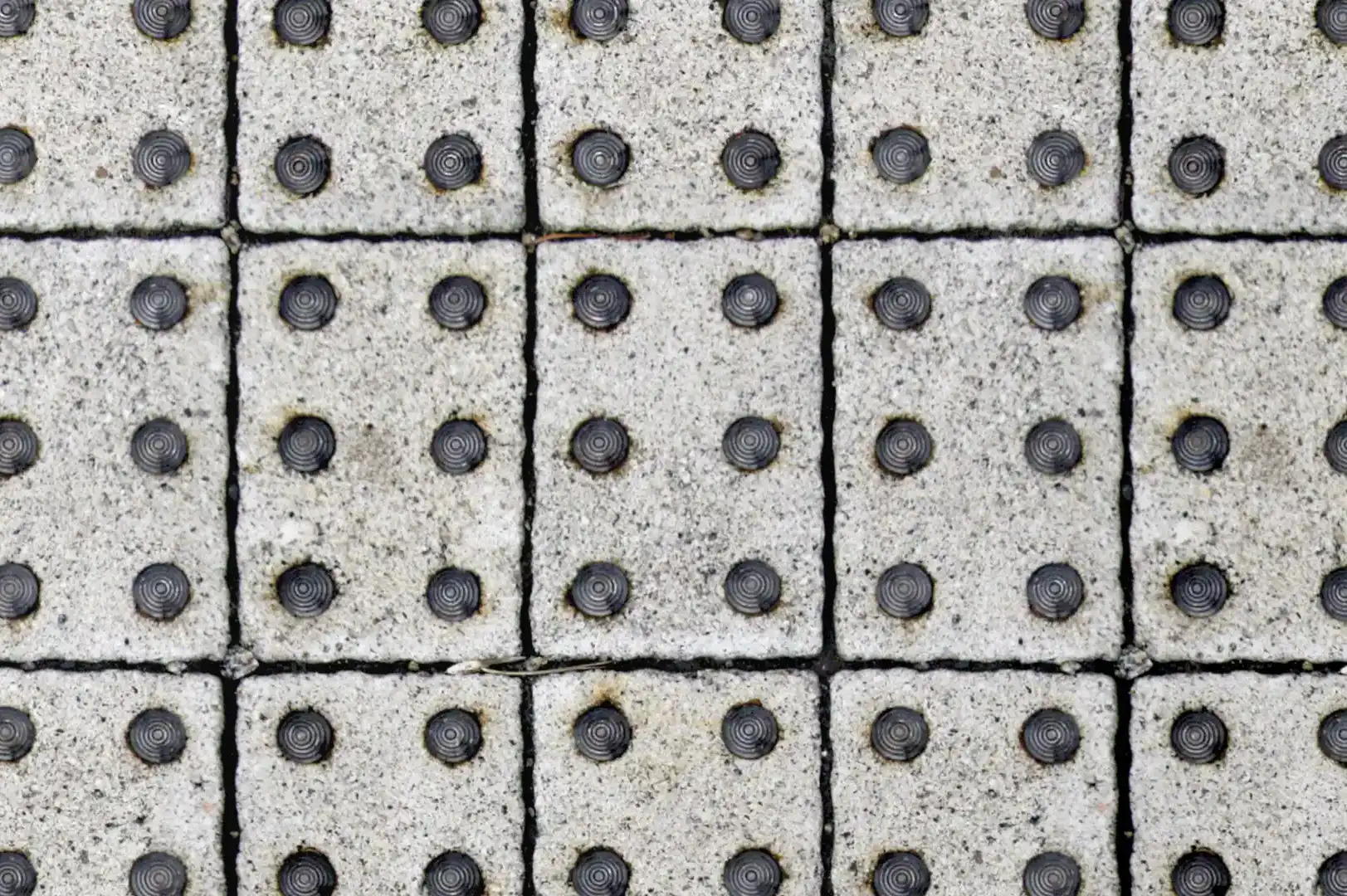 Close-up of concrete pavers with round anti slip steel studs