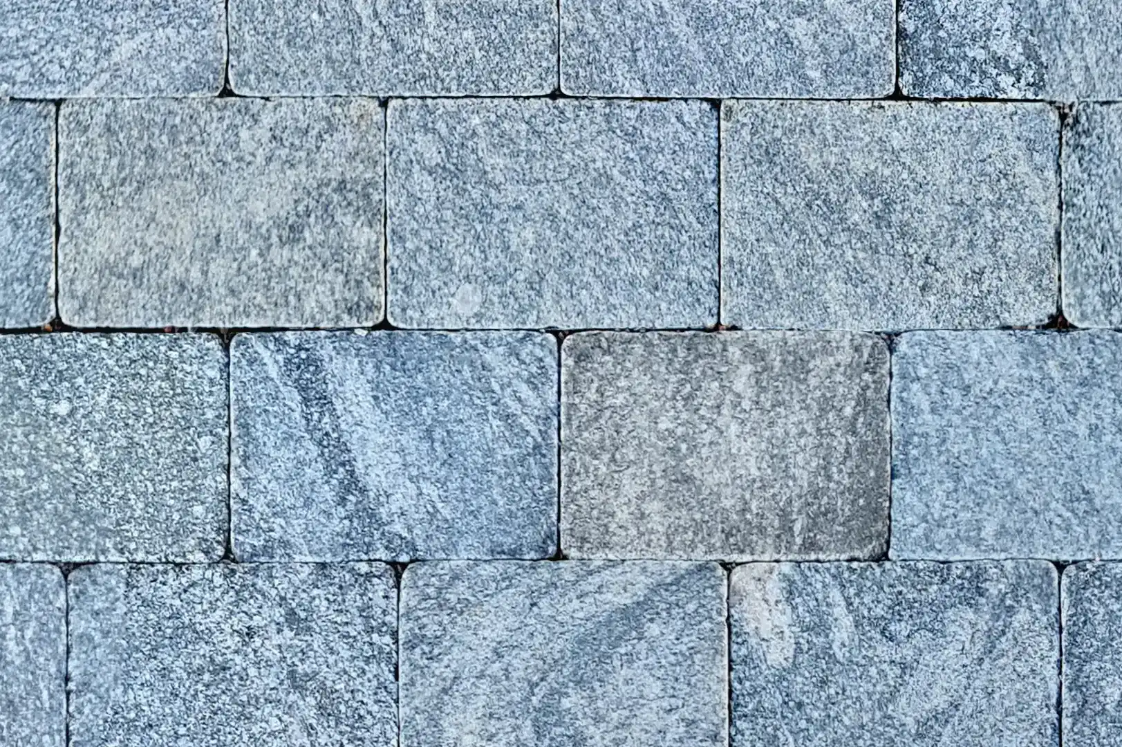 Close-up of a rectangular stone pavement with striated finish