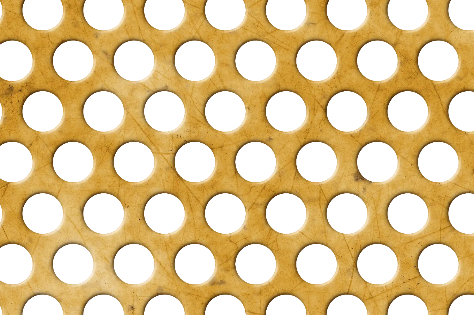 Close-up of a scratched copper perforated metal panel with circular holes