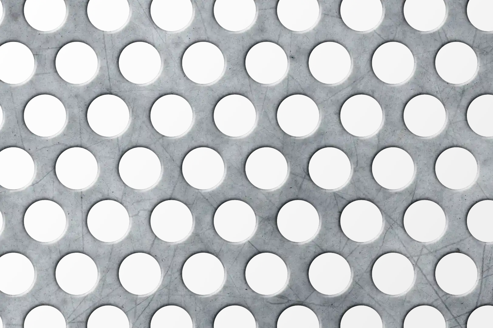 Close-up of a scratched perforated metal panel with circular holes