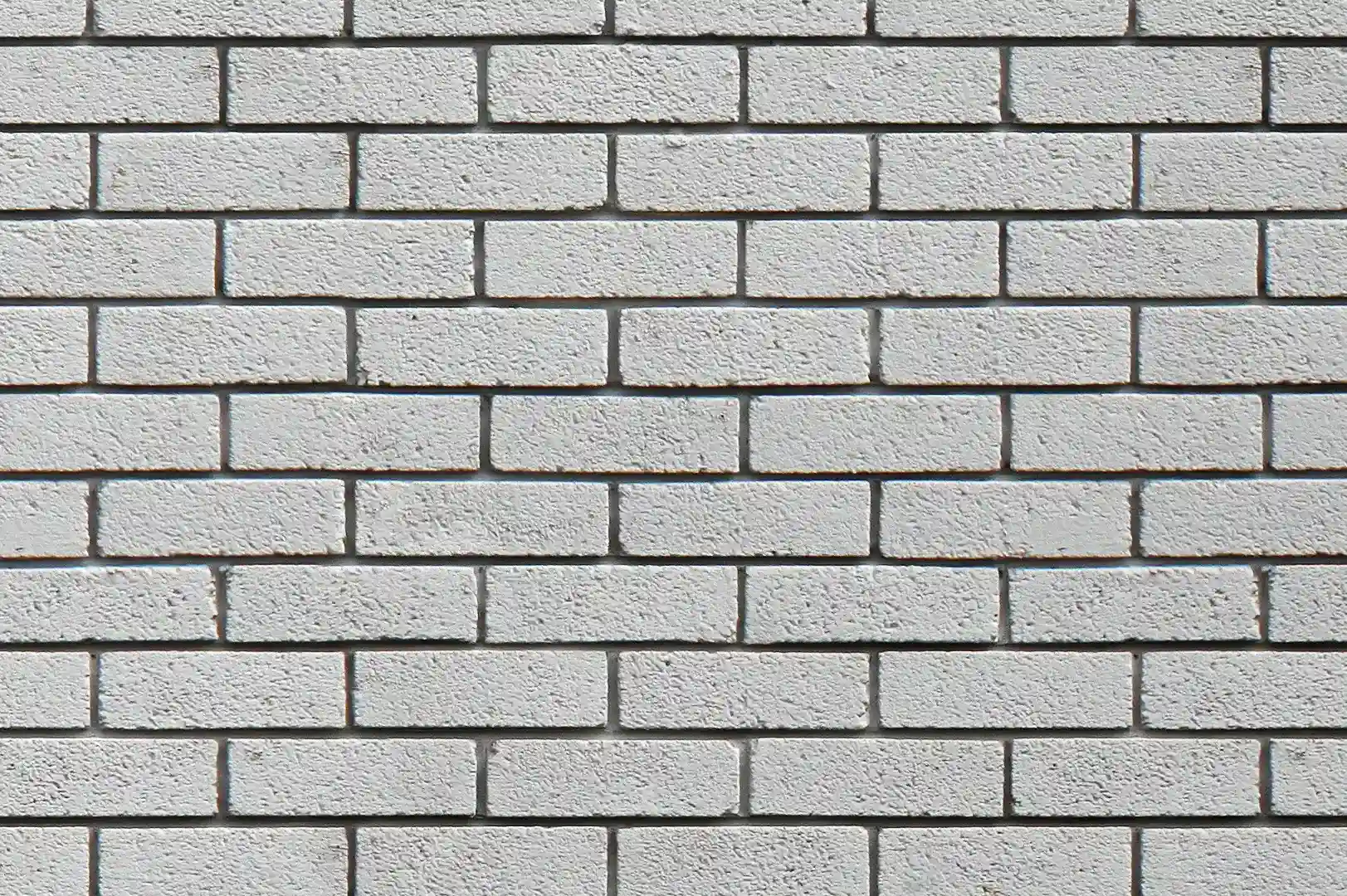 Close-up of a white painted brick wall with recessed joints