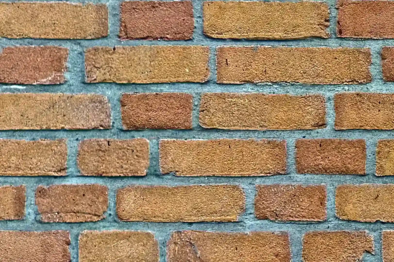 Close-up of a light brown brick wall with abrasive surface