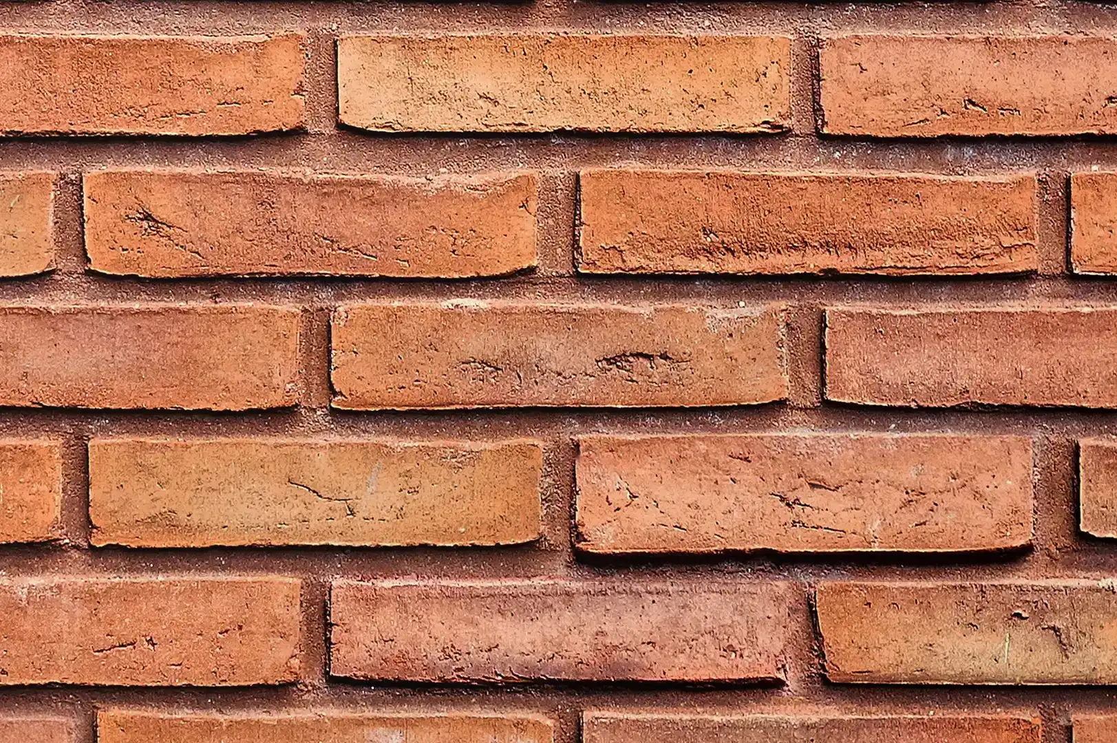 Close-up of a brown brick wall with raked joints