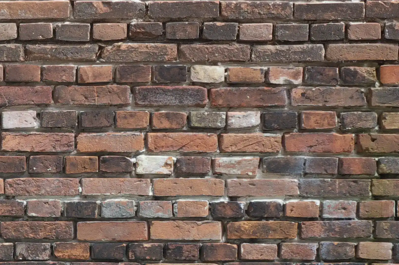 Close-up of a brick wall with dark aged bricks