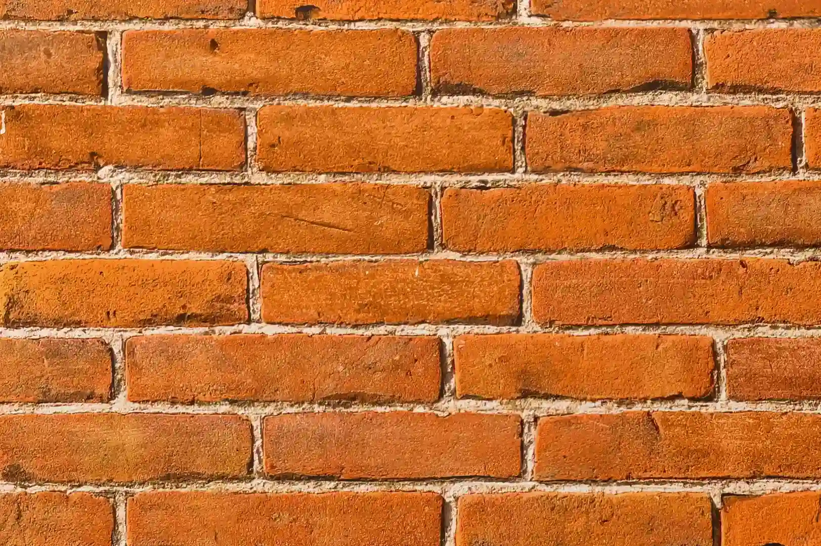 Close-up of a bright red decorative brick wall with porous surface