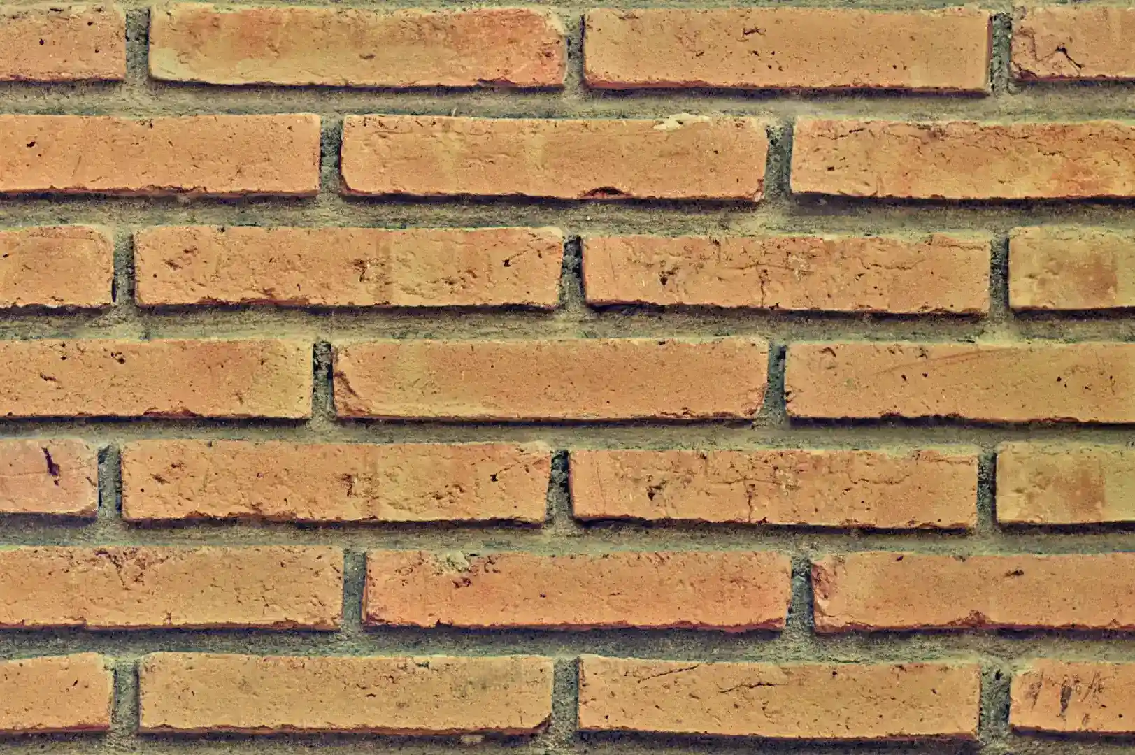 Close-up of a light brown decorative brick wall with recessed joint