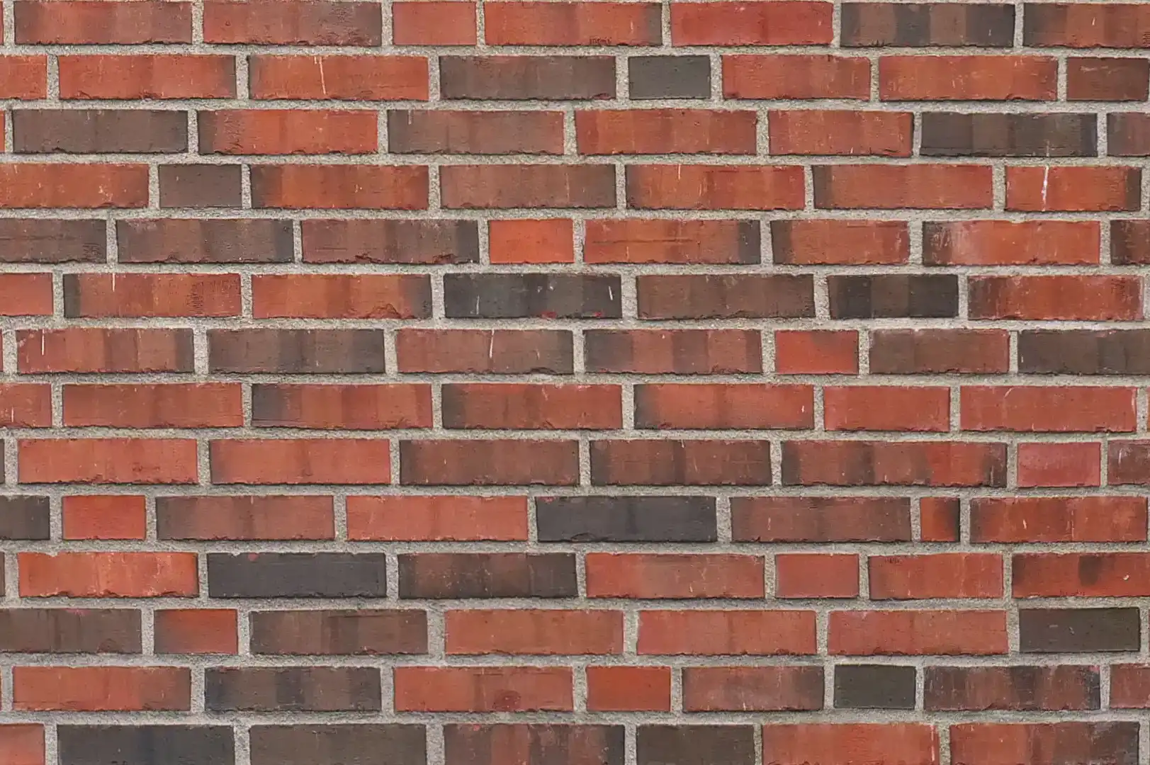 Close-up of a decorative brick wall with black and dark red bricks