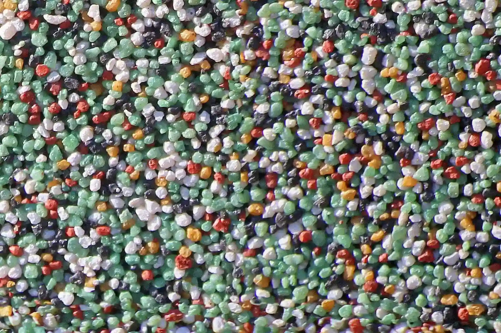 Close-up of a plaster wall with colorful small pebbles