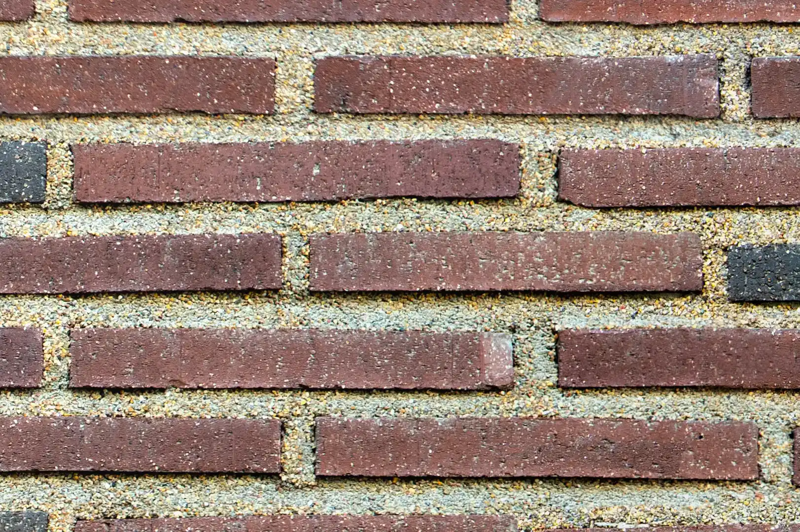 Close-up of a brick wall with elongated red and black bricks