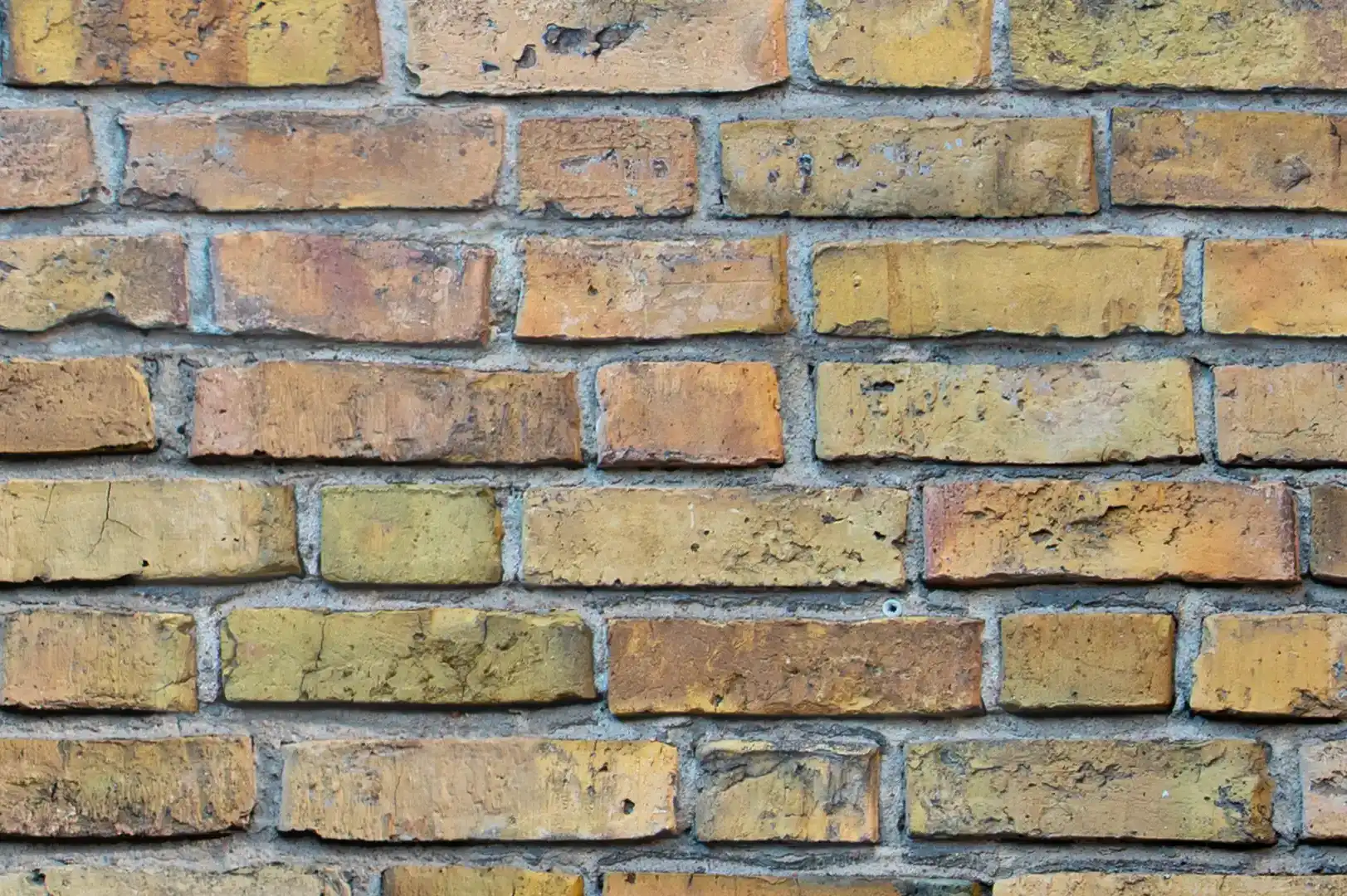 Close-up of a brick wall with ochre and yellow tinted bricks