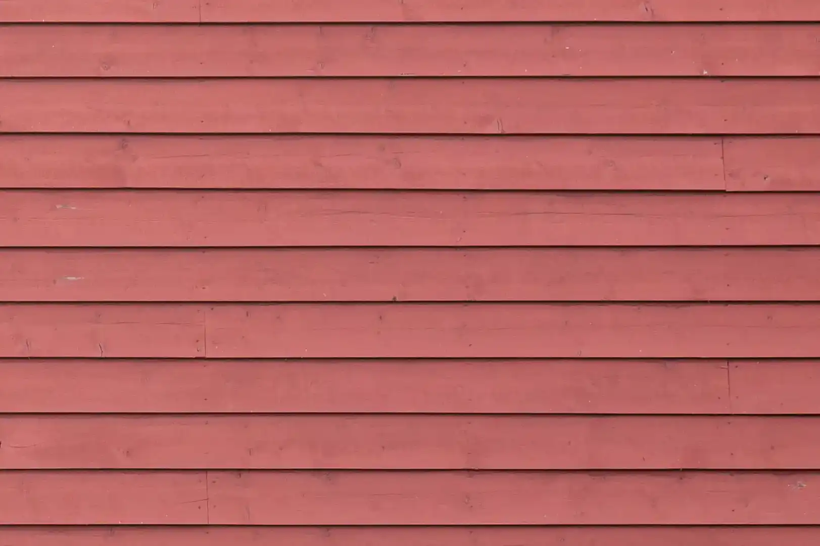Close-up of an exterior horizontal overlapping wood planks cladding painted in reddish brown