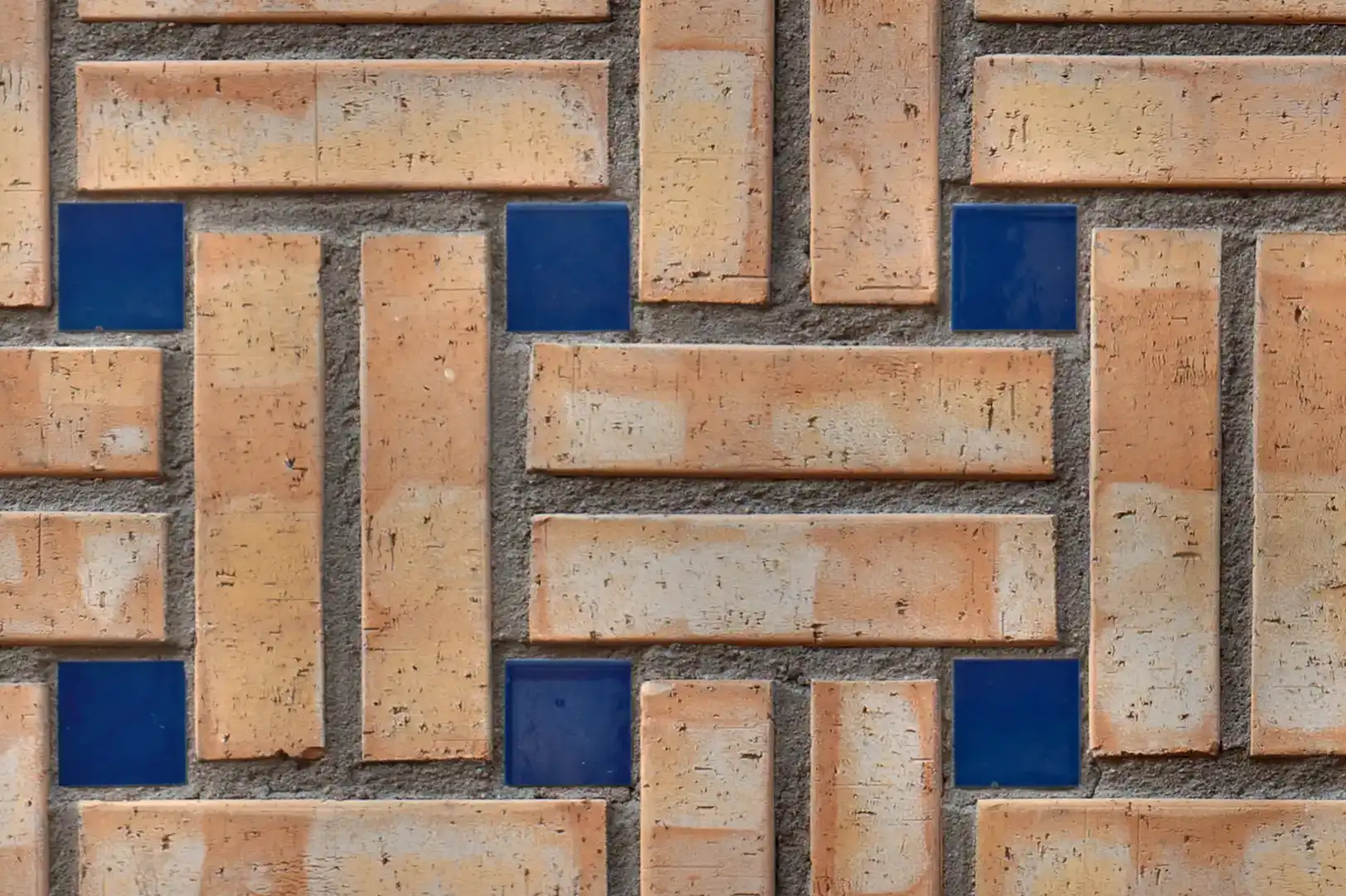 Close-up of a decorative crosshatch brick wall with additional glazed blue squares elements