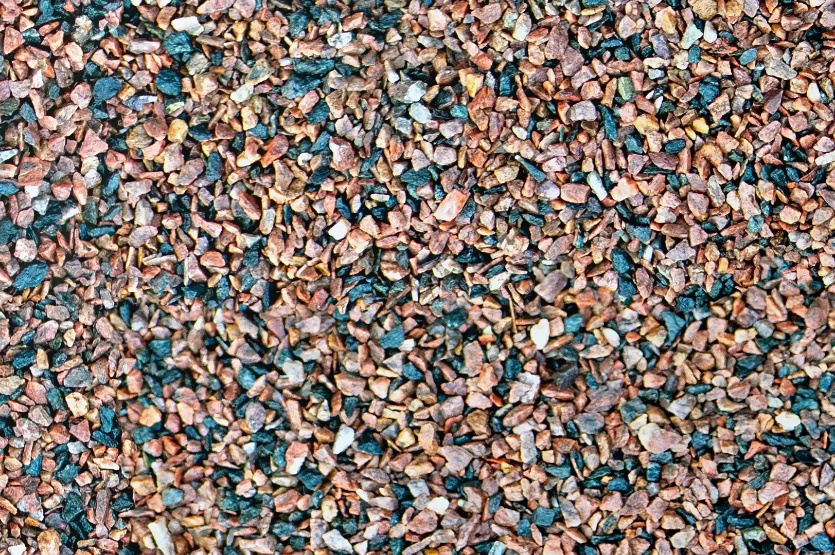 Close-up of a field with decorative blue, red and ochre gravel