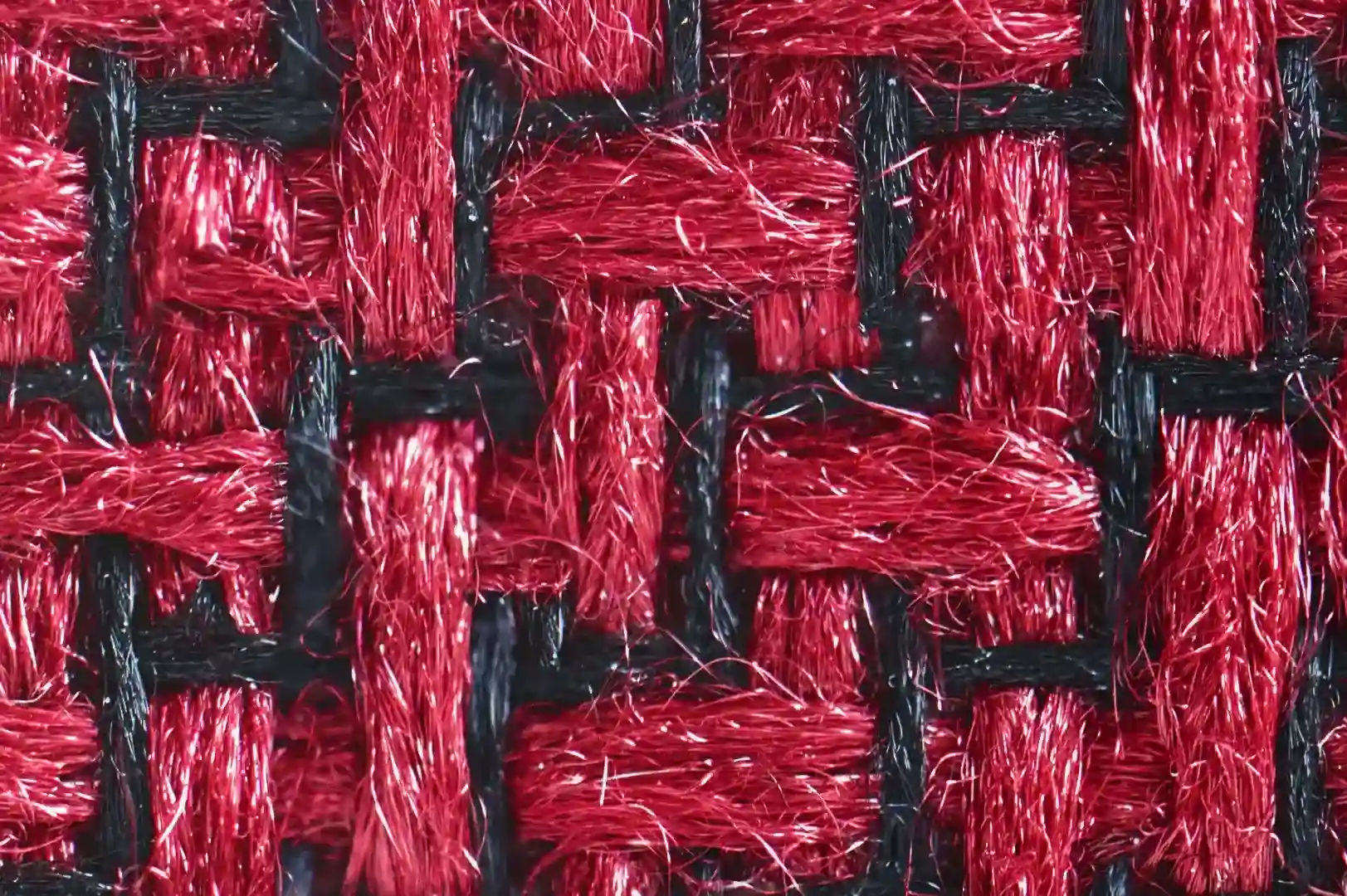 Close-up of a plastic textile with red and black fibers woven in zigzag