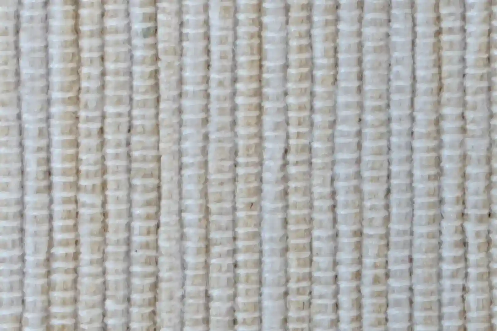 Close-up of a simple handwoven rug with white and beige color tones