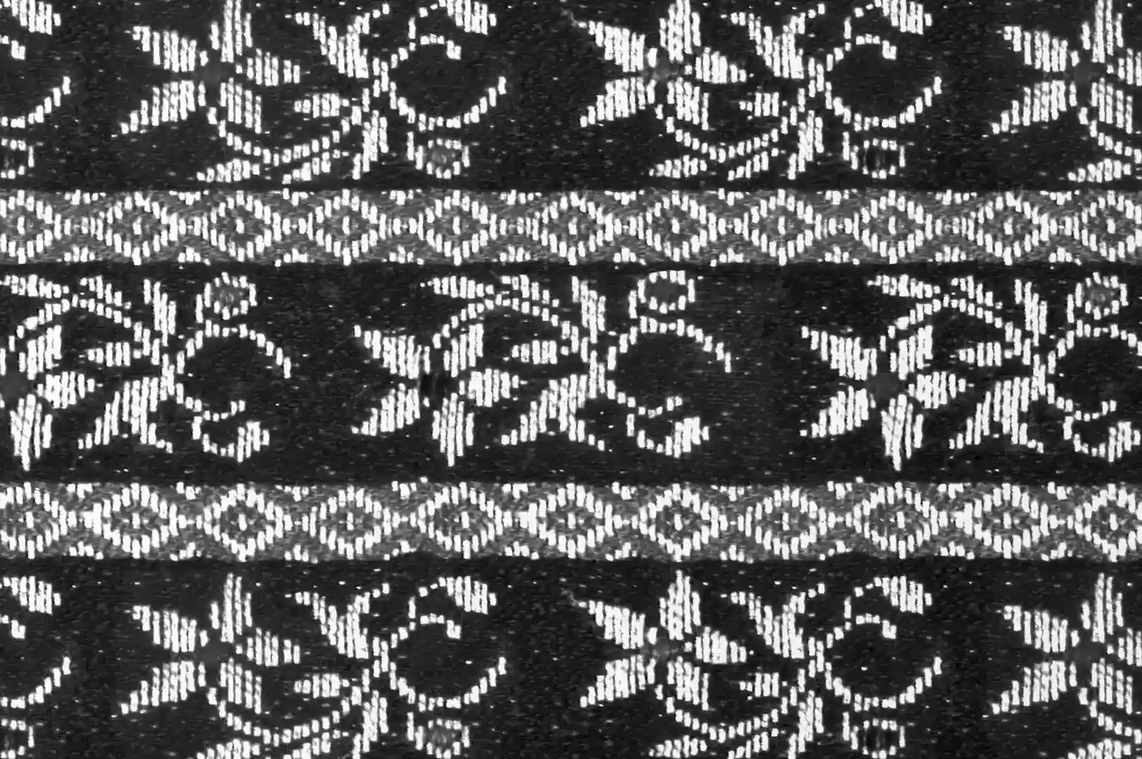 Close-up of a hand embroidery floral cloth with geometric rhomb shapes