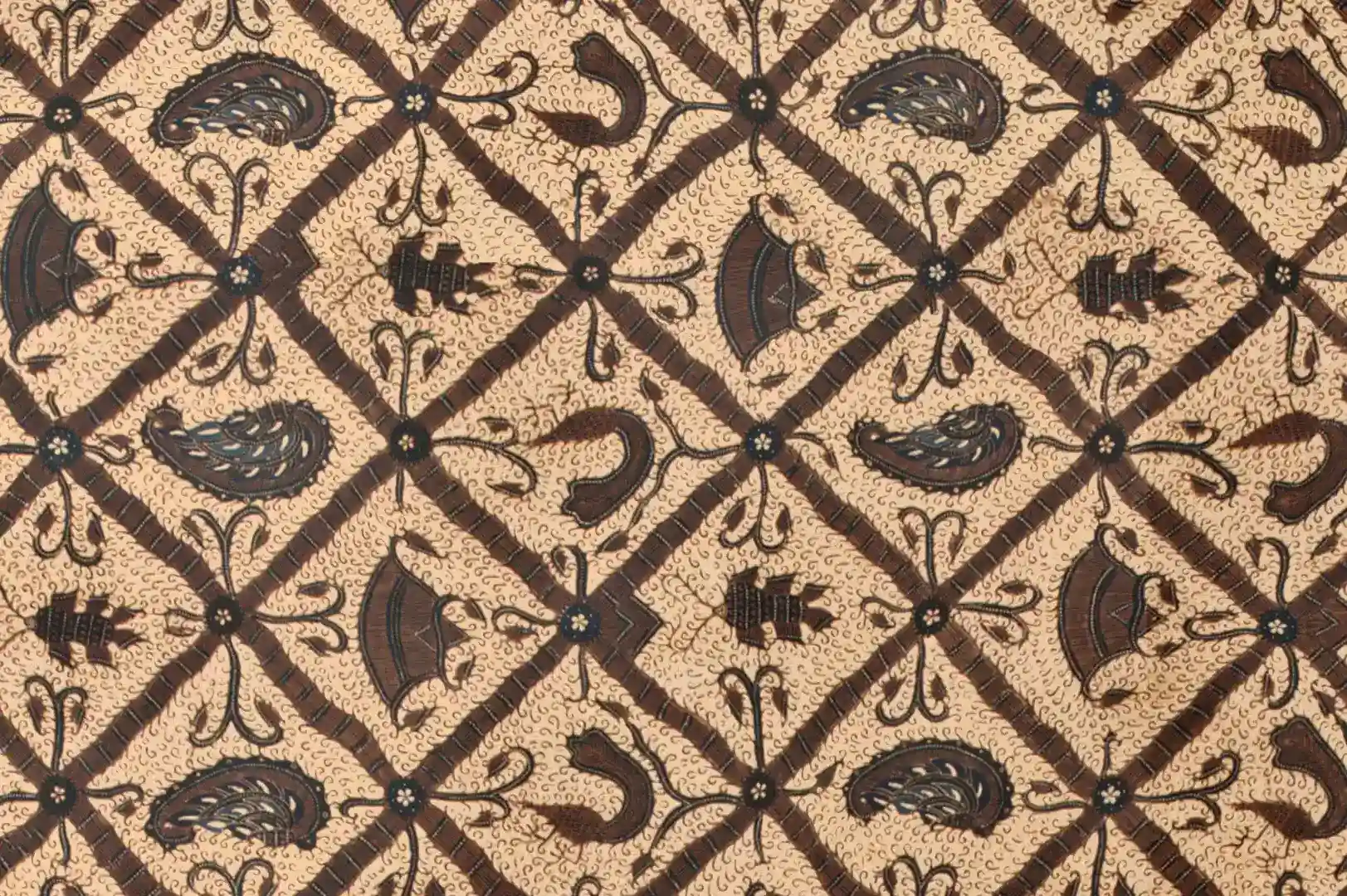 Close-up of a hand painted batik with diamond shapes and floral motifs