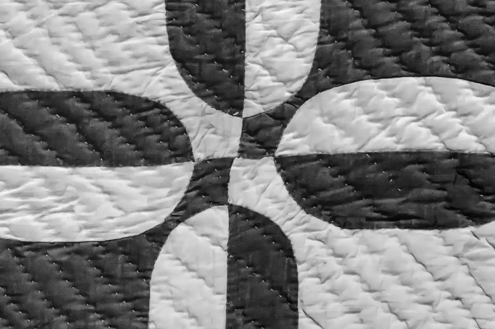 Close-up of a quilted duvet with geometric black and white pattern