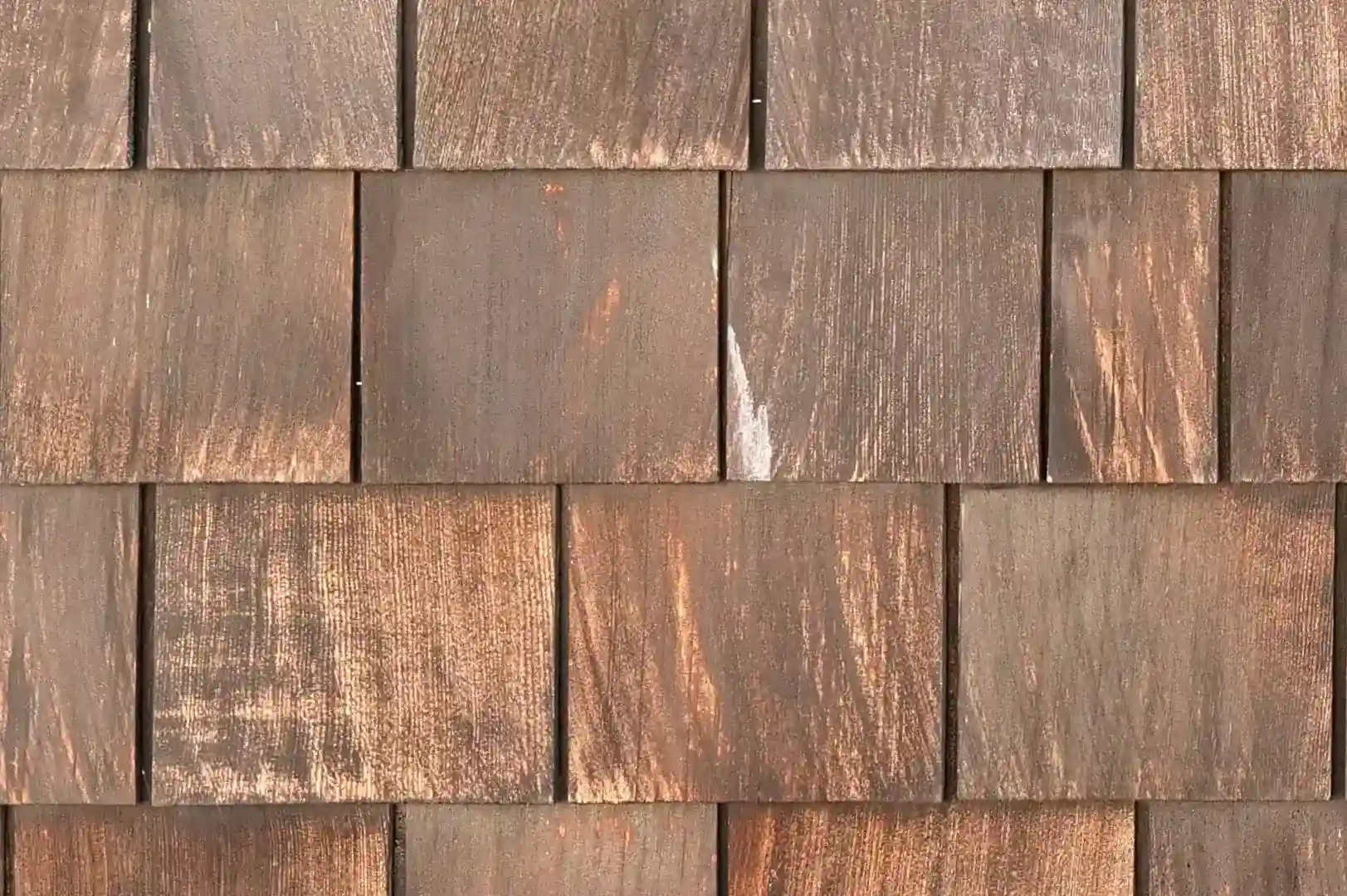 Close-up of a vertical wall covered with natural rough wood shingles